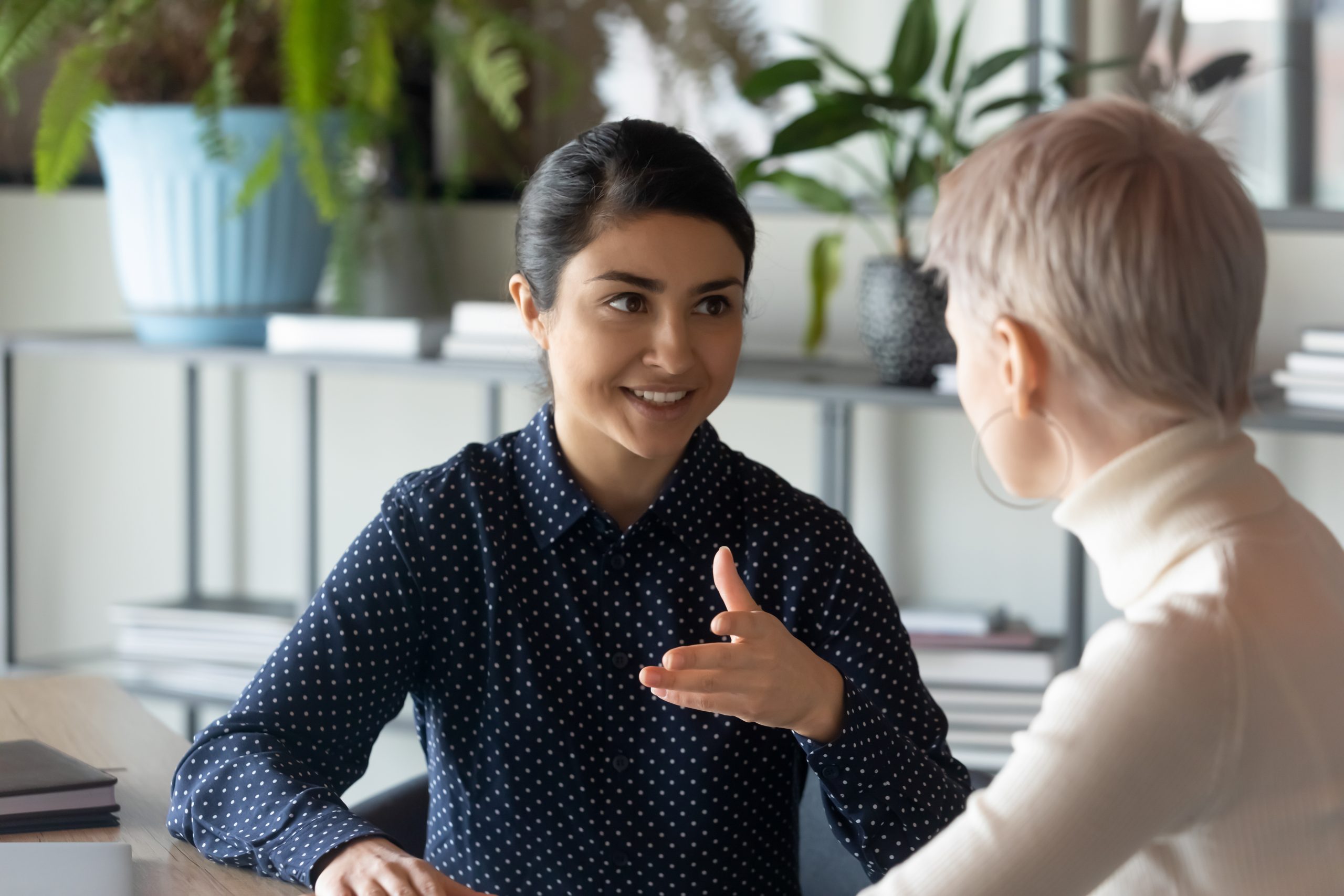 Two smiling coworkers sharing feedback 